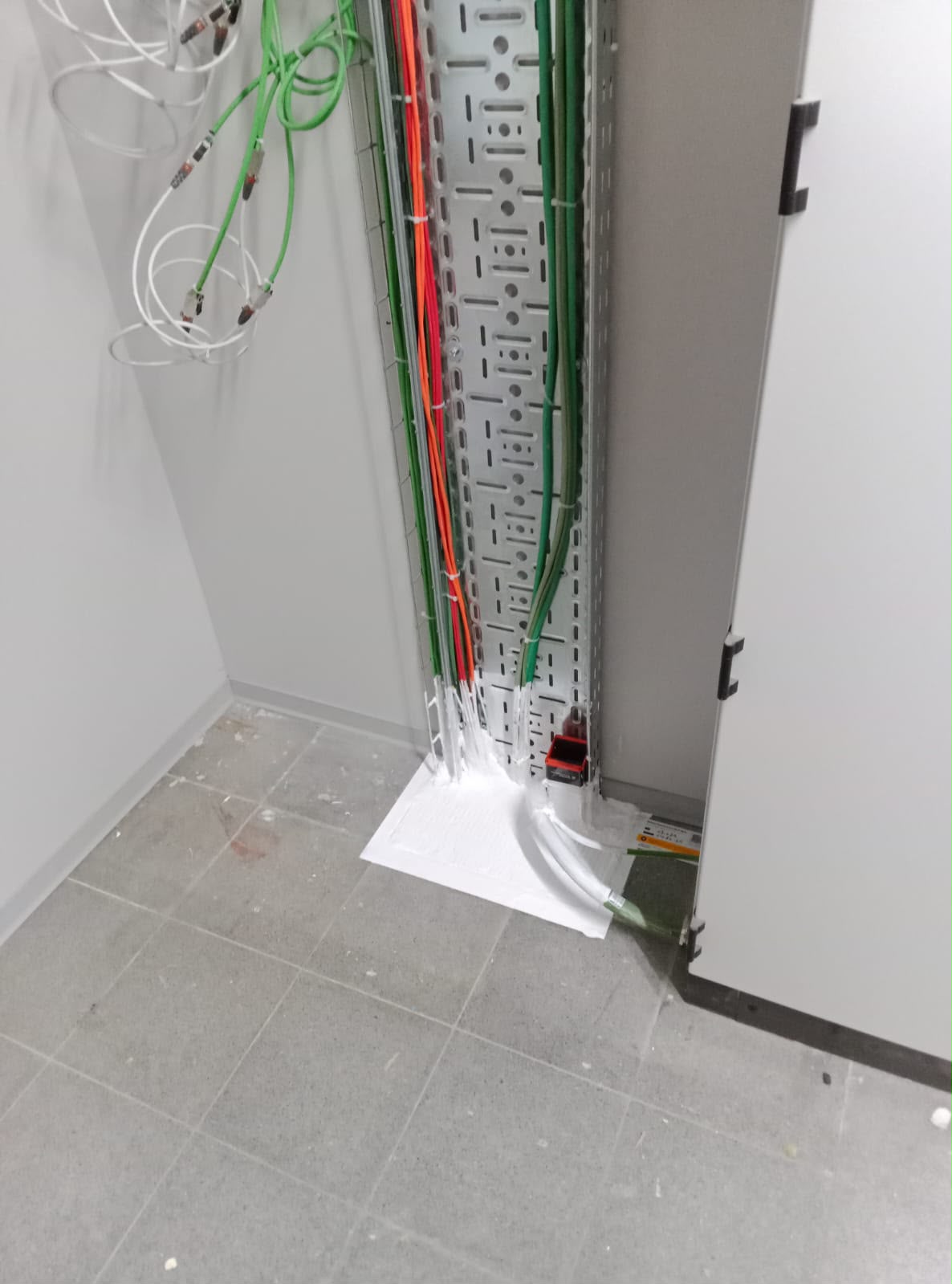 Cable tray penetration through a floor slab, sealed against fire