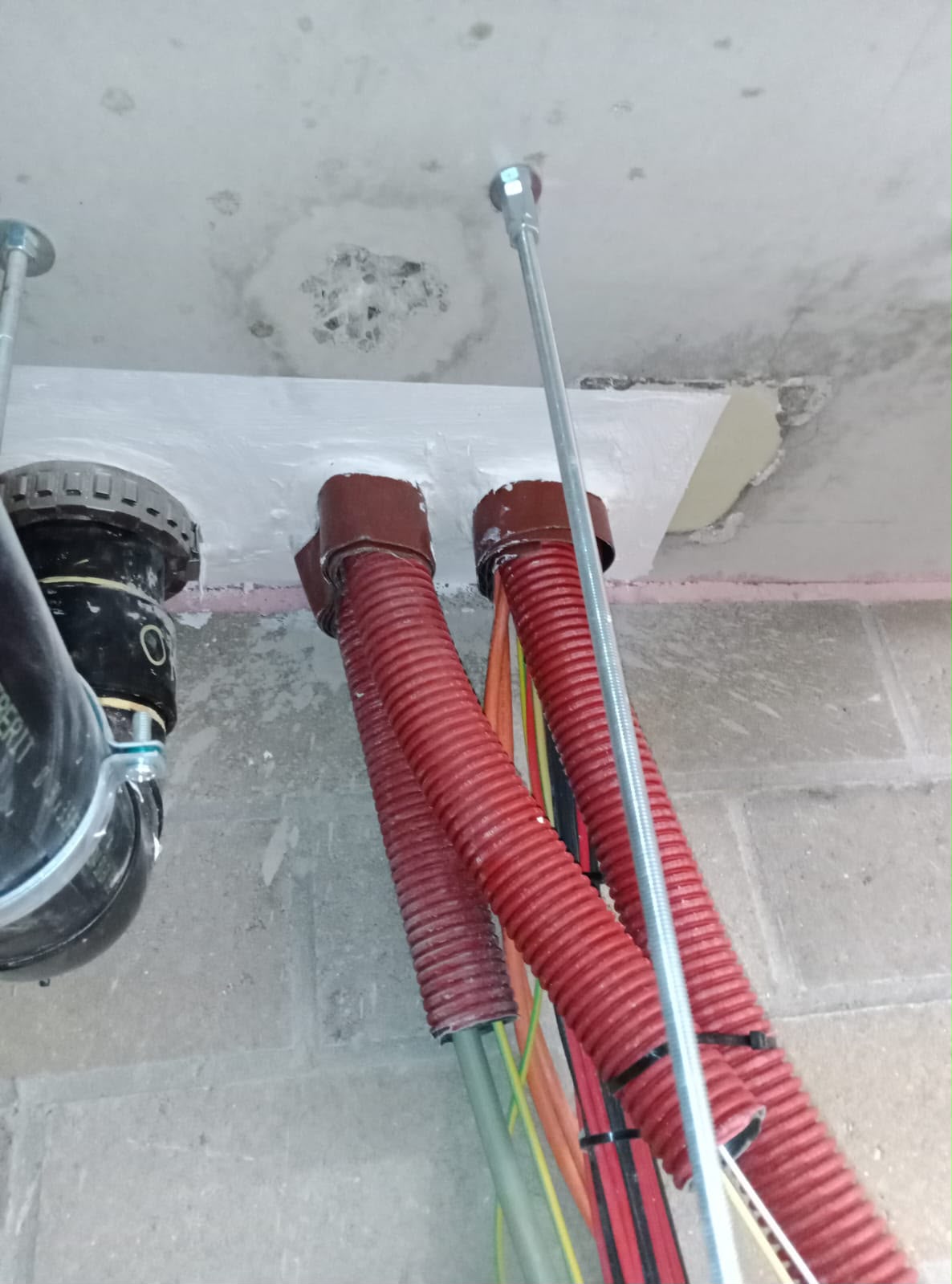Service conduits through a slab fitted with firestop collars
